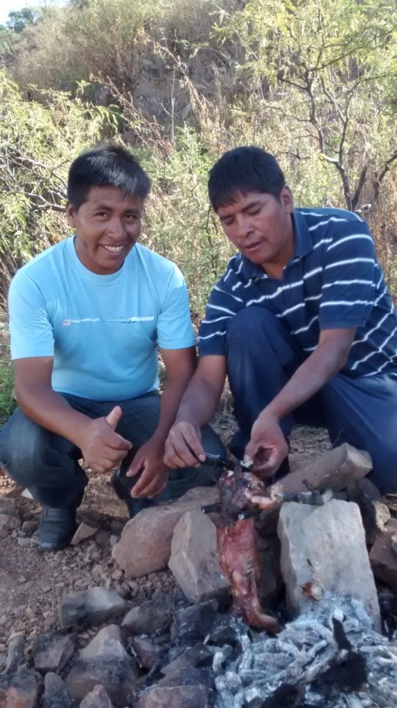 Elias and Mateo watching the viscacha cook